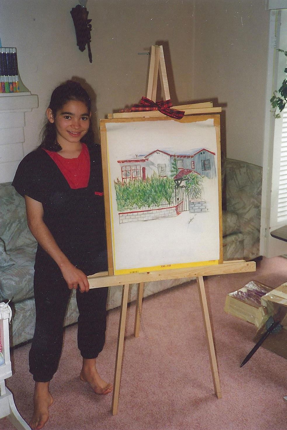 Young Erin Hanson with a painting of her house