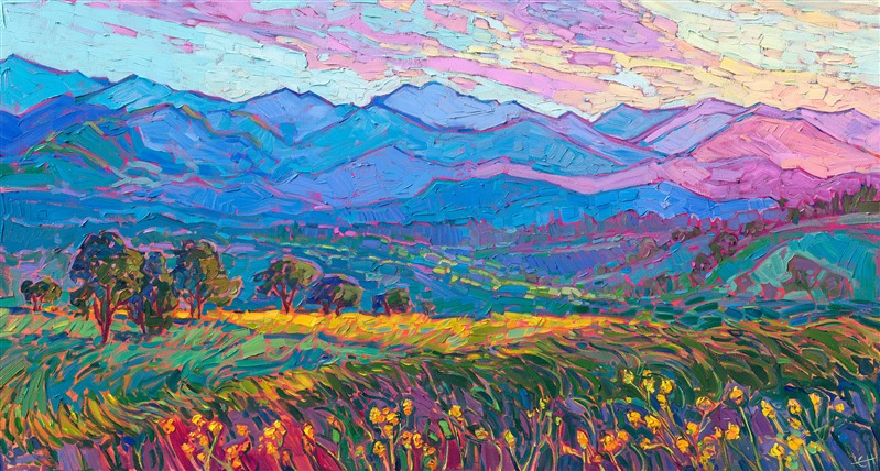 The coastal range bordering the Willamette Valley in Oregon transforms into a luminescent pattern of contrasting colors as the sun sets below the opposing mountain range. Rich hues of ultramarine blue, turquoise, and purple are layering into the fading distance. In the foreground, fields of early summer mustard plants are in bloom.