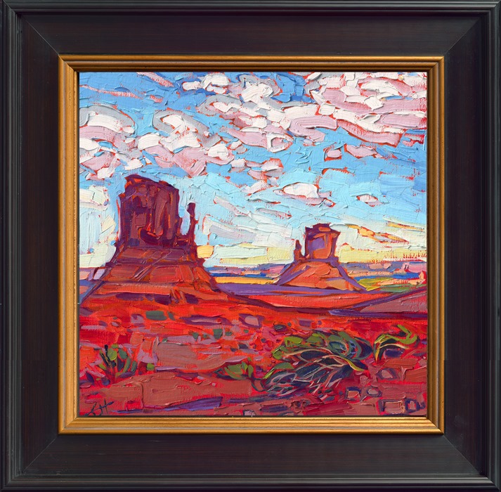Monument Valley is captured in rich hues of red against a baby blue sky. The brush strokes are thick and impressionistic, alive with color and texture.</p><p>"Monument Clouds" is an original oil painting on linen board. The piece arrives framed in a black and gold plein air frame.