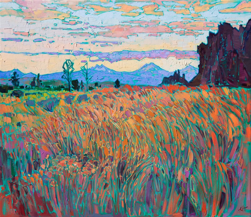 Smith Rock is a popular rock climbing destination near Bend, Oregon. You can see the peaks of the Three Sisters in the distance, blue against the warm hues of the setting sky. The long grasses in the foreground glow with the colors of summer.</p><p>"Smith Rock" was created on 1-1/2" canvas, with the painting continued around the edges. The painting arrives framed in a contemporary gold floater frame, ready to hang.