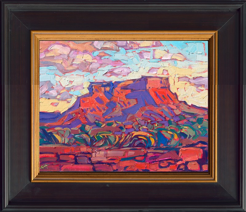 A red rock butte between Monument Valley and Mexican Hat glows with the colors of sunset in the high desert. The pale green sage bushes stand out starkly against the dark red earth. Luscious brush strokes of oil paint carve out the texture of the desert landscape.</p><p>"Utah Butte" is an original oil painting on linen board. The piece arrives framed in a plein air frame.